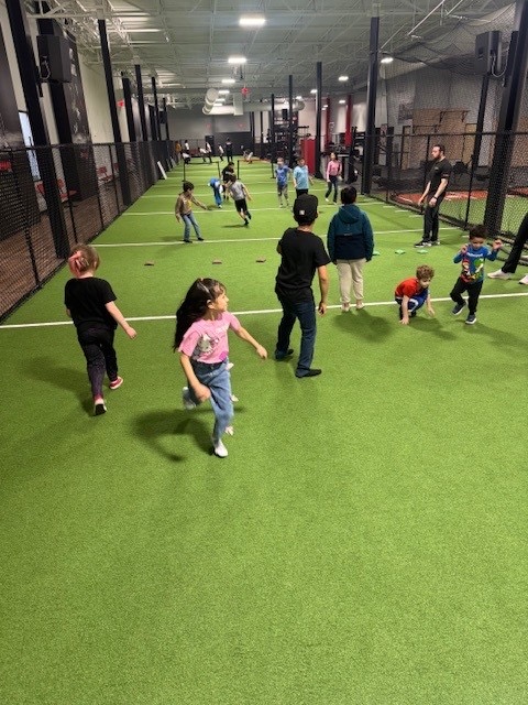 Kids playing a supervised game on the indoor turf during a party